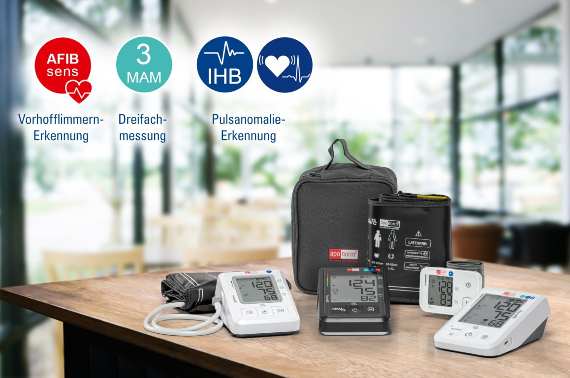 Aponorm Blutdruckmessgeräte: vier verschiedene Modelle mit Tasche liegen auf einem holzernen Tisch. Der Hintergrund ist verschwommen.