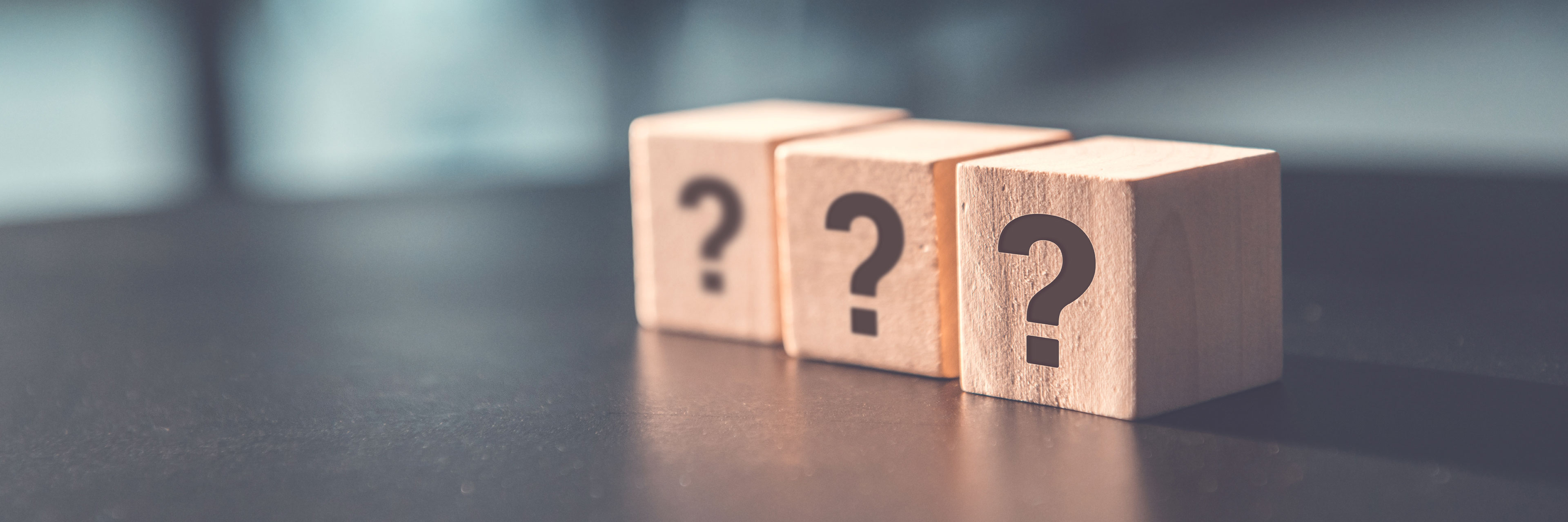 FAQ Drei Holzteine mit einem Fragezeichen nebeneinander